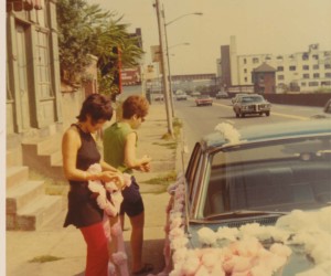 1970 Decorating cars with carnations for a wedding. Marohnic Book Store on left