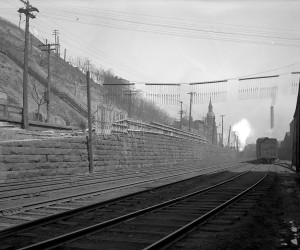 1921 - View of an old stone wall on  E. Ohio Street. St. Nicholas Church is in the background  715.216027.CP **